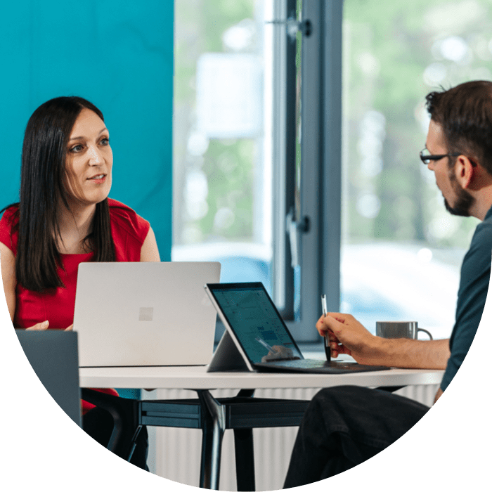 man and woman sat at table with laptops