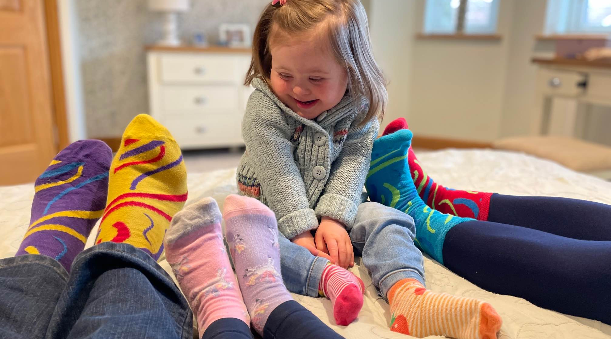 Charlotte Whillis who lives with Down Syndrome with her and her family's odd socks